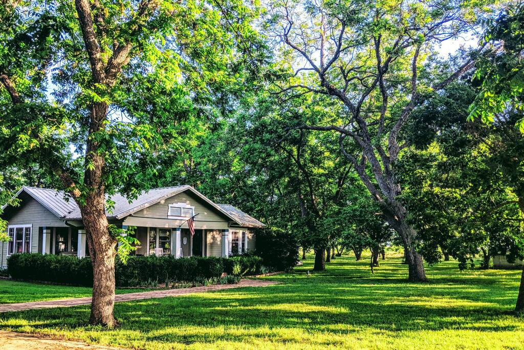 Soak in the beauty of the pecan orchard on this sprawling wrap around porch! Just kick back or enjoy a family dinner on the six person dining table.