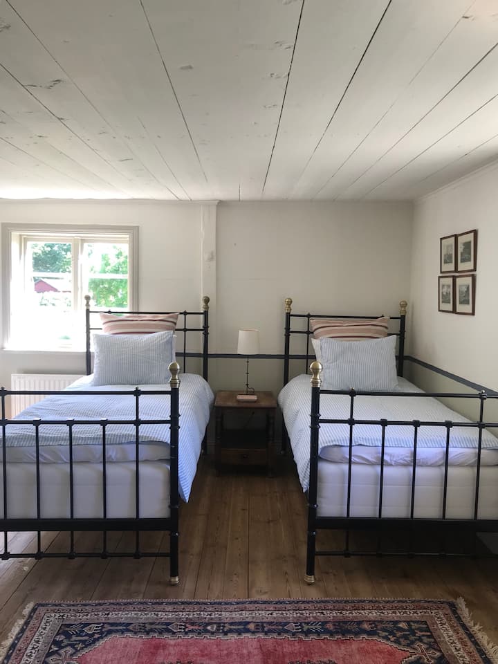 חדר שינה 1 עם שתי מיטות יחיד ושפע של מקום למיטה נוספת.