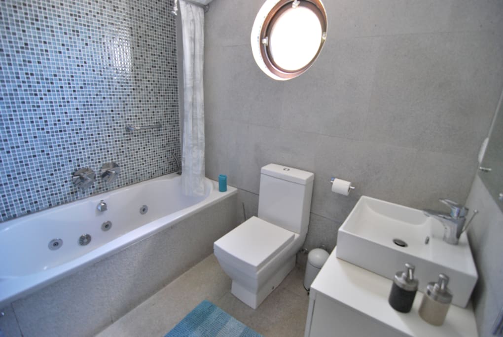 The bathroom is modern with shower/bath/jacuzzi