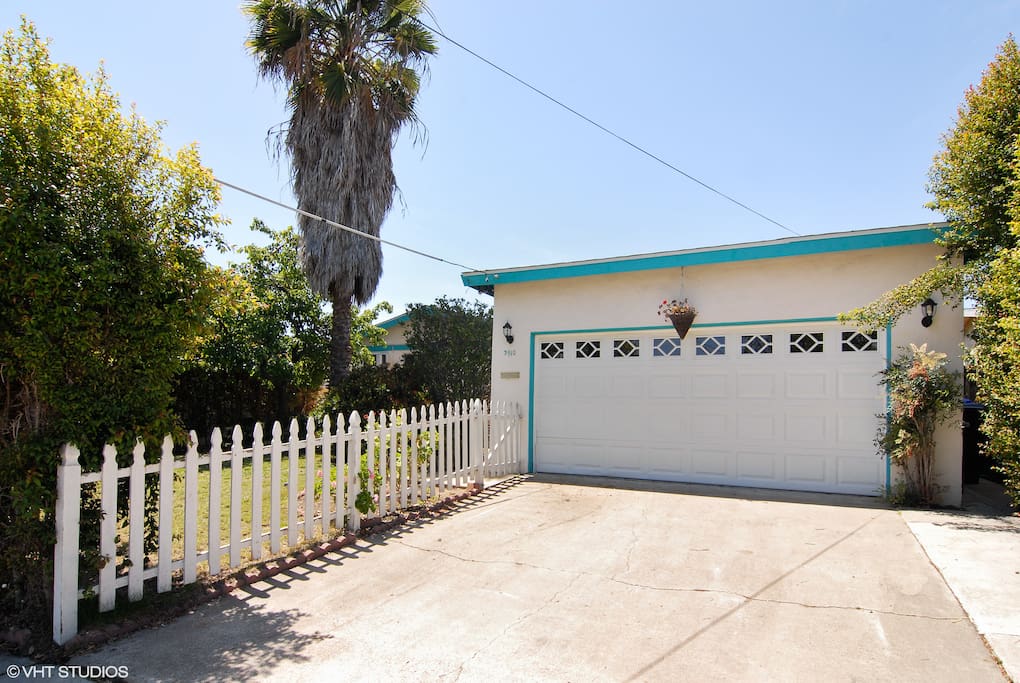 Nice private front yard with private patio, garden, palm tree, fire pit and white picket fence!