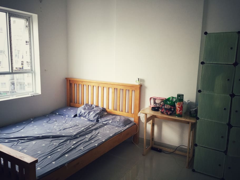 Bed room with double bed next to a bright window
