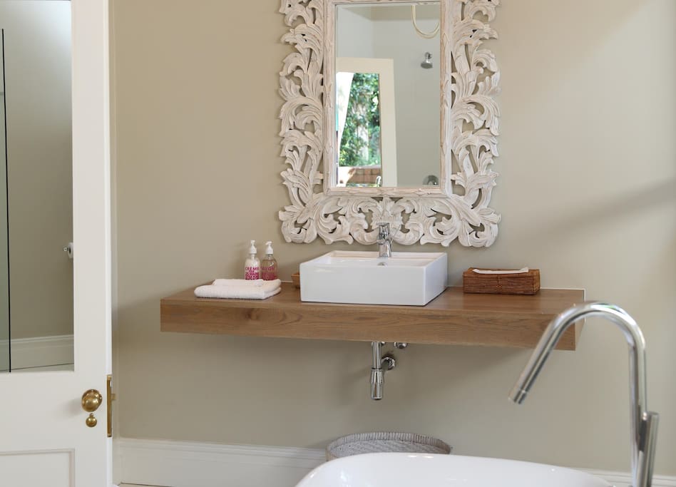 The bathroom features a free standing bath and shower