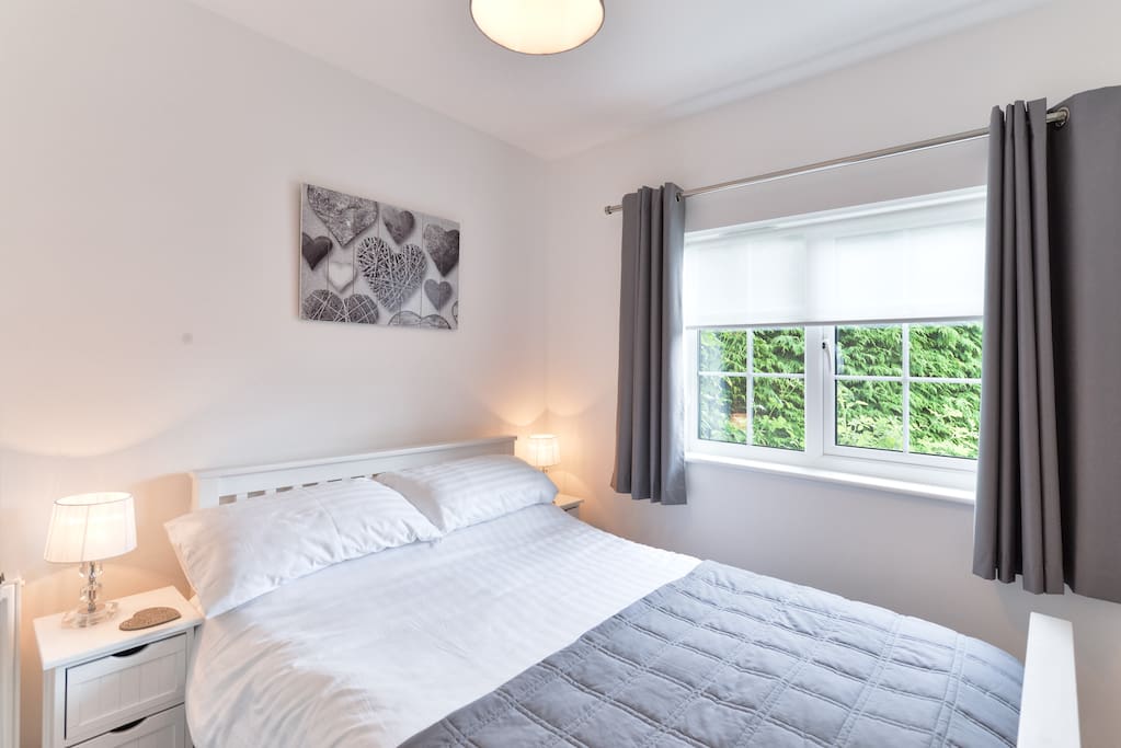 Bedroom with a small double bed, wardrobe and side cabinets.