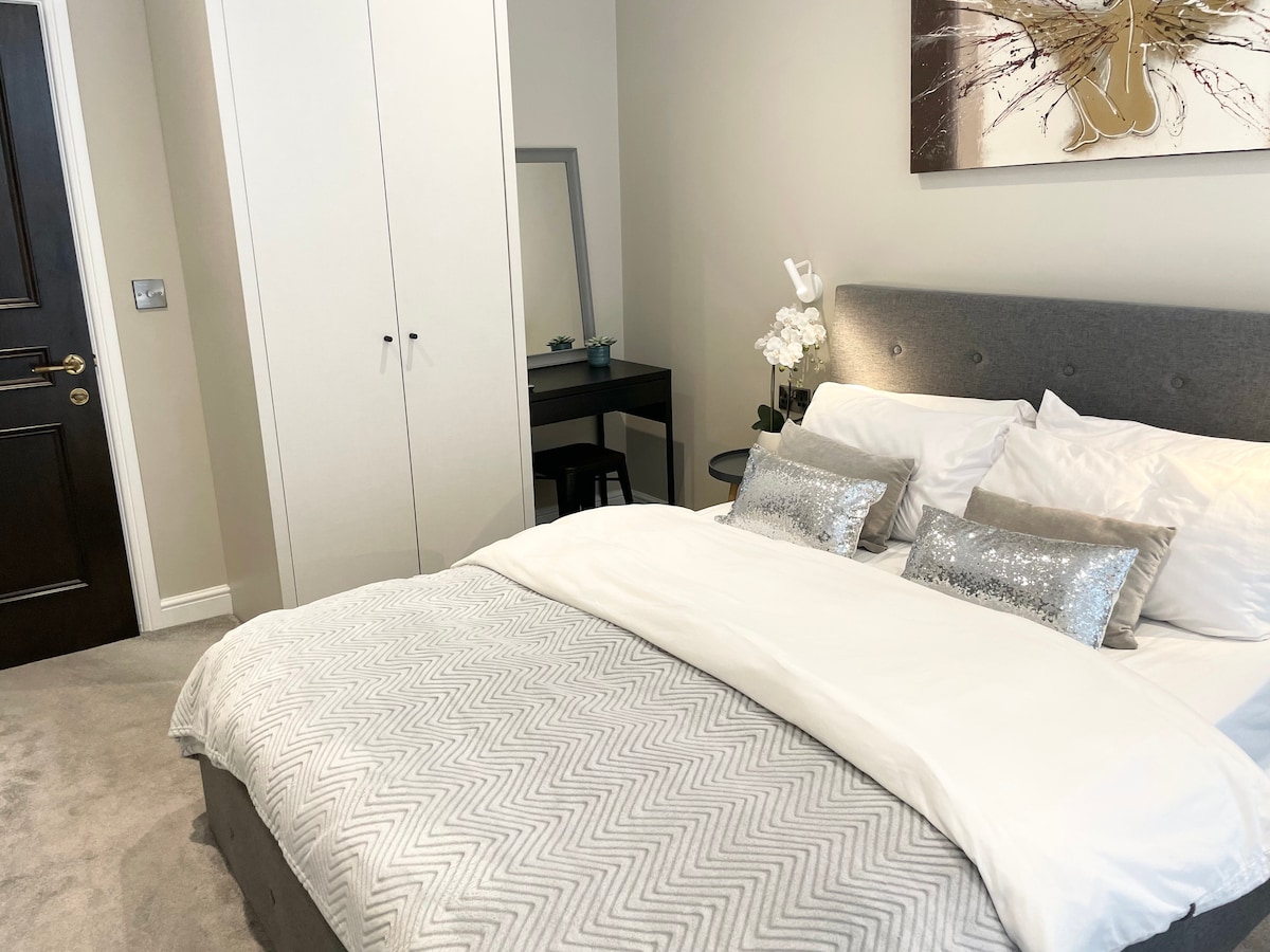 In the bedroom there is a king size bed with hotel quality bedding for the best nights sleep. There are wooden shutters on the window, a dressing table with hairdryer provided and a wardrobe with iron and ironing board in. 