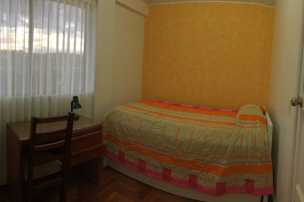 Habitación con cama de plaza y media y una cama auxiliar