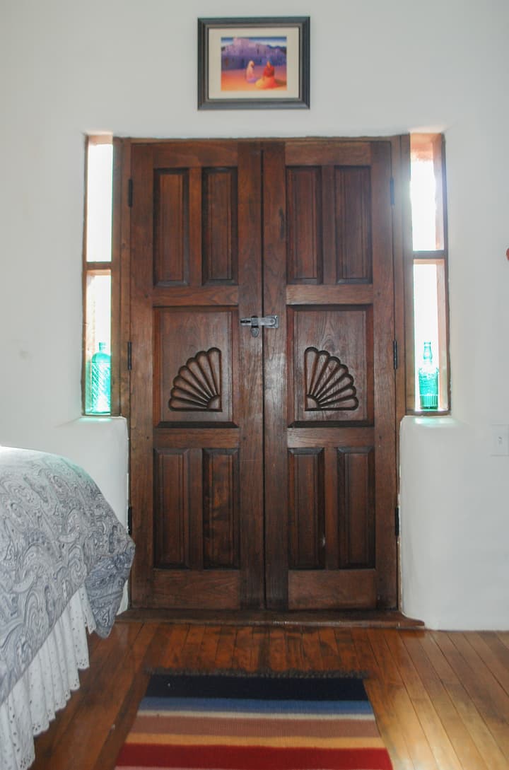 Entrada exterior al patio privado con comedor al aire libre y sombrilla