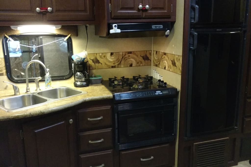 Kitchen with microwave, half-time & convection oven, 3 burner range and refrigerator/freezer