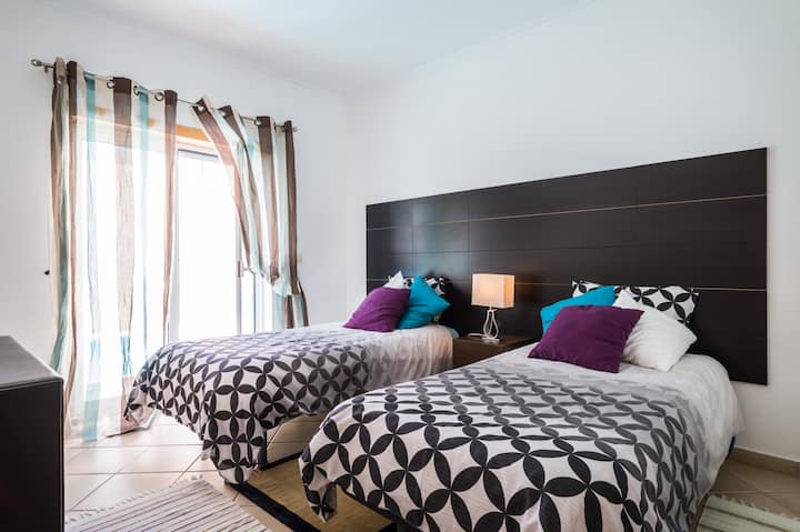 明亮的卧室，配备2张单人床（可成为2米宽双人床）室外可使用泳池