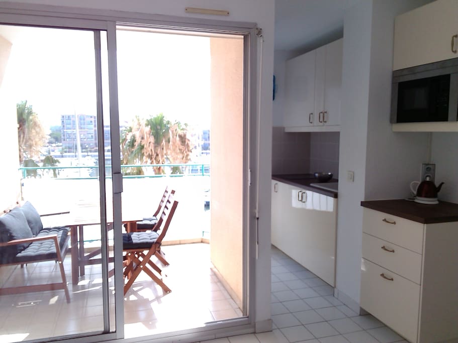 Salon avec vue sur le port et cuisine équipée.