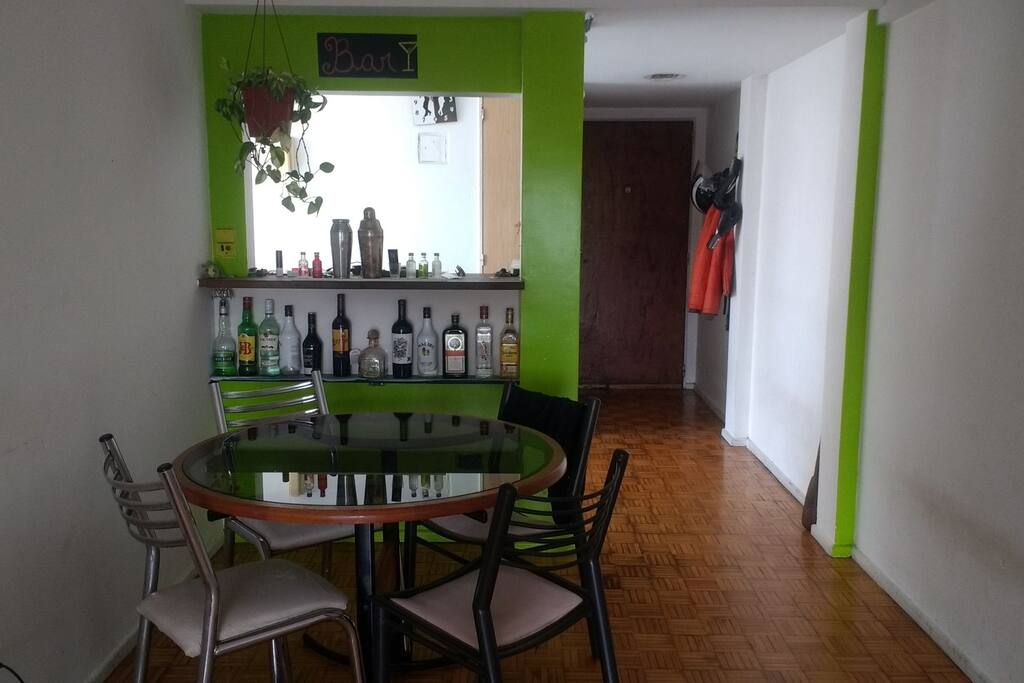 Living comedor, al fondo la puerta de entrada y del otro lado de la barra la cocina