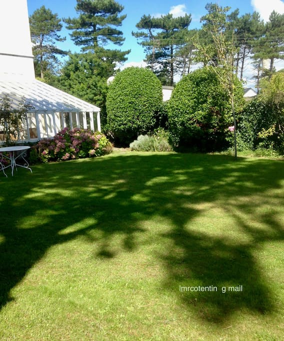 la véranda très accueillante le jour comme le soir avec vue sur le jardin arrière