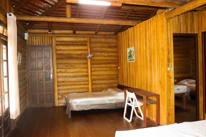 Habitación grande con dos camas dobles y acceso a otros dos dormitorios y un baño.