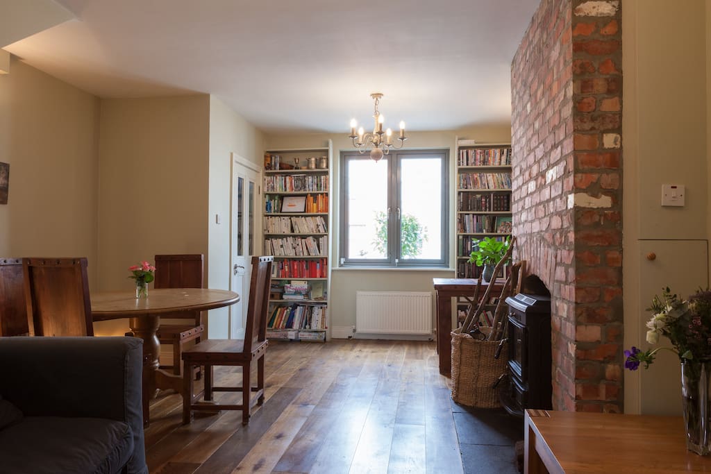 Spacious living room with brick fireplace and iron stove
