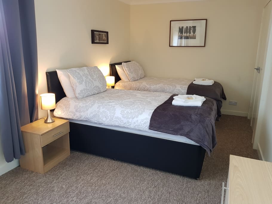 Bedroom 1 Twin Room, with two bedside tables a wardrobe and chest of drawers
