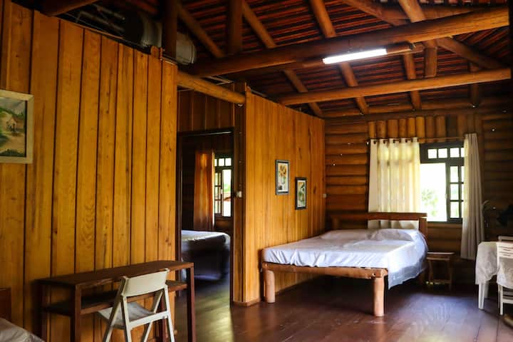 Habitación grande con dos camas dobles y acceso a otros dos dormitorios y un baño.