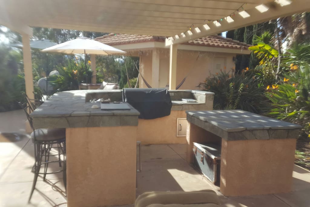Outdoor gourmet kitchen with built in barbecue sink and refrigeration. Built for outdoor grill days in a very private setting.