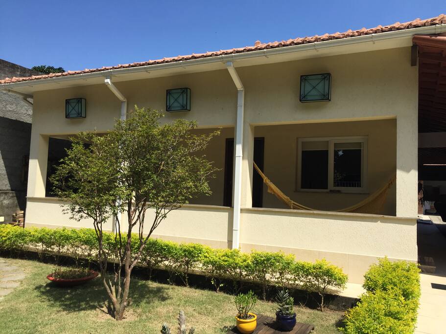 Frente da casa, jardim e varanda com 2 redes