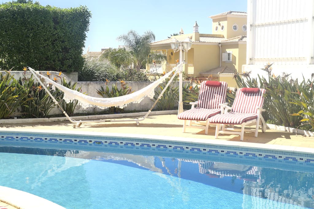 Pool area with sunbeds, hammock, barbecue,
table and chairs.
