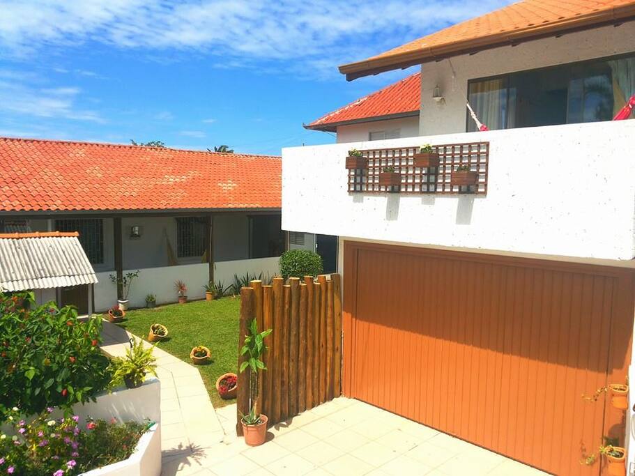 Entrada da casa com garagem para 2 carros. Uma vaga coberta e outra descoberta.