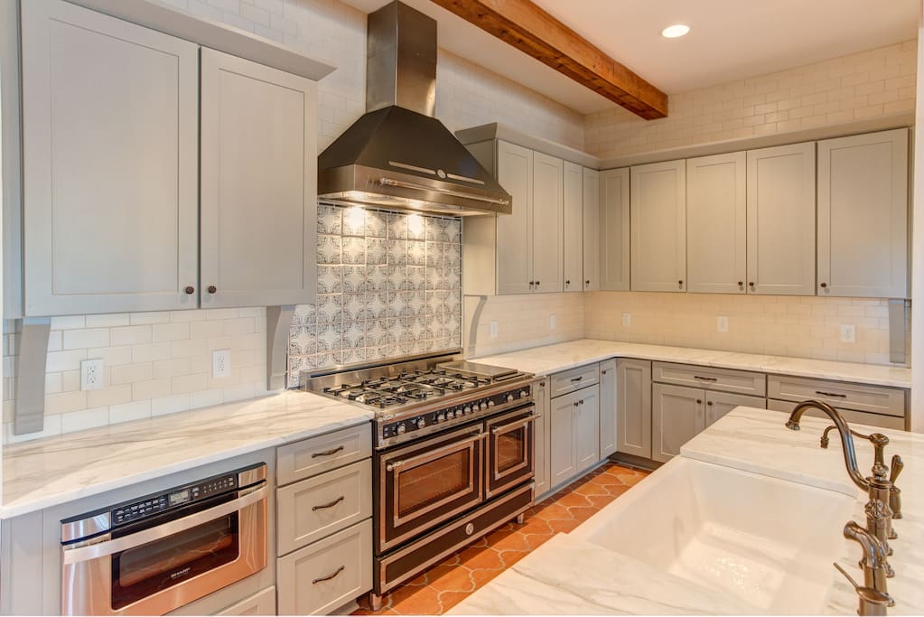 Custom cabinets, handmade tile, Italian gas range, high end marble in kitchen.