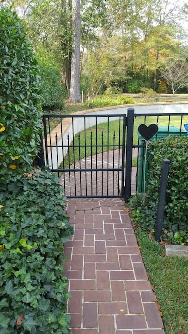 Enter through iron gate into backyard.
