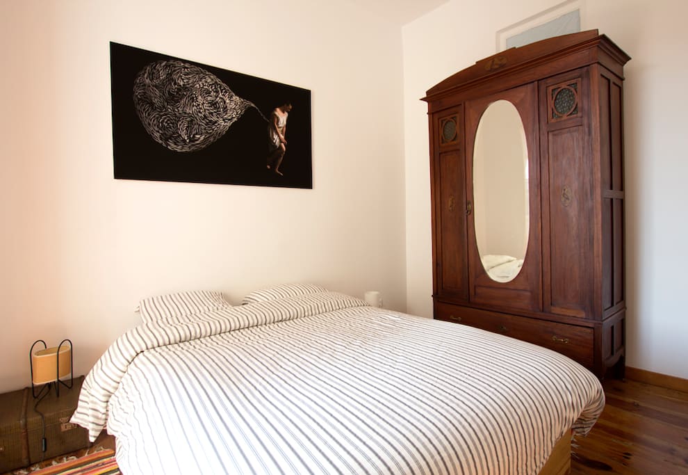 Os quartos deste apartamento foram cuidadosamente decorados, como se tratasse de habitação própria. A mobília enquadra-se com a idade do prédio. Este é um dos dois quartos com camas de casal.