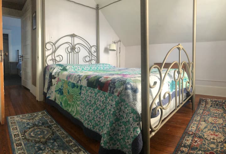 La cama con dosel de tamaño completo tiene un colchón con la parte superior acolchada.