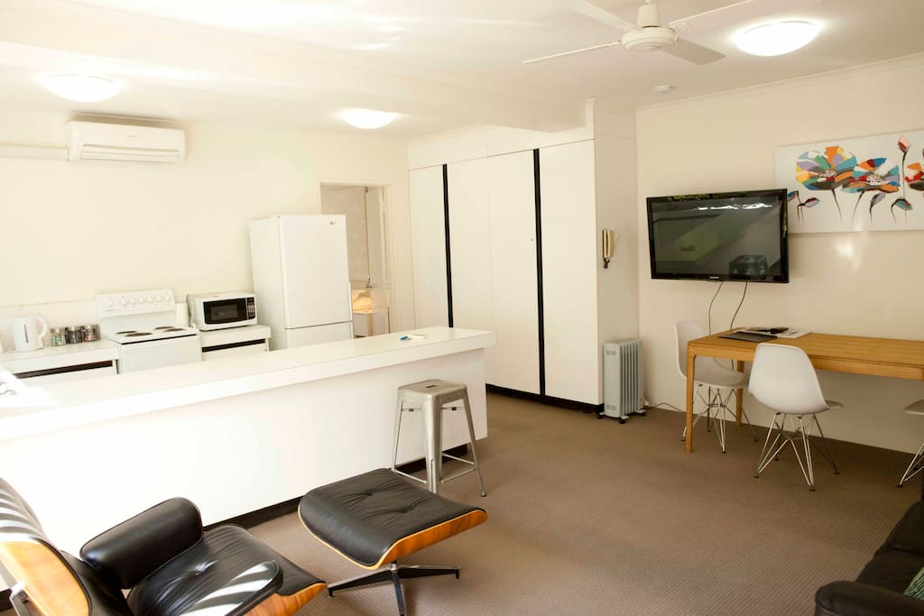 Kitchen and Living area showing large TV and Pantry Cupboard