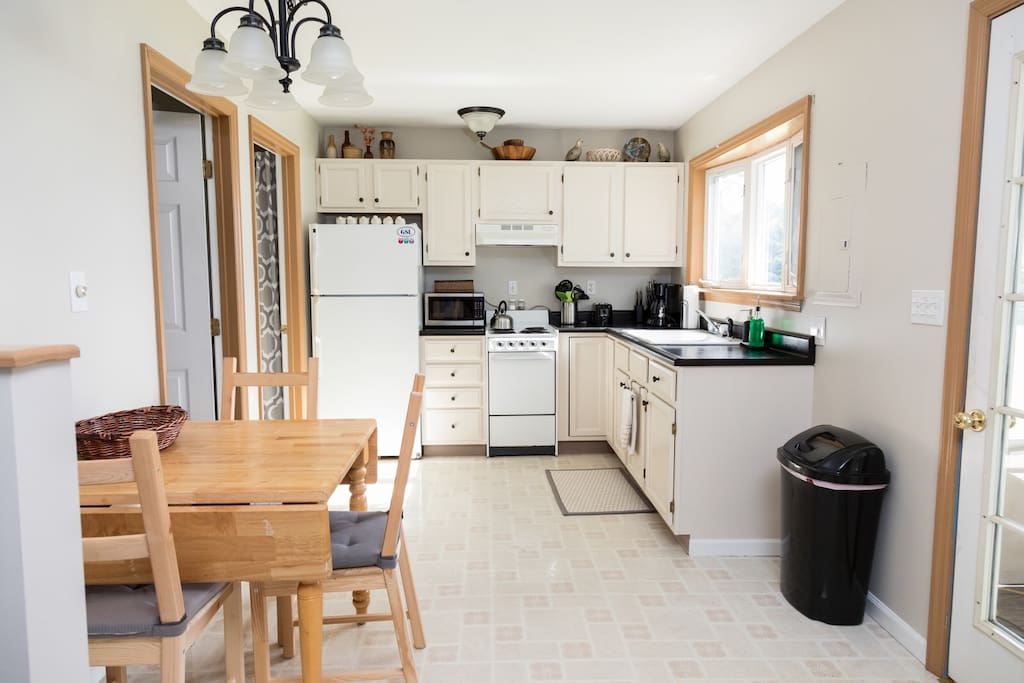 Kitchen with microwave, stove, coffee maker, dishes and other necessities