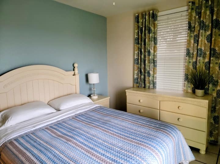 חדר שינה עם מיטת קווין סייז. דלת ההזזה שמובילה לפטיו האחורי.