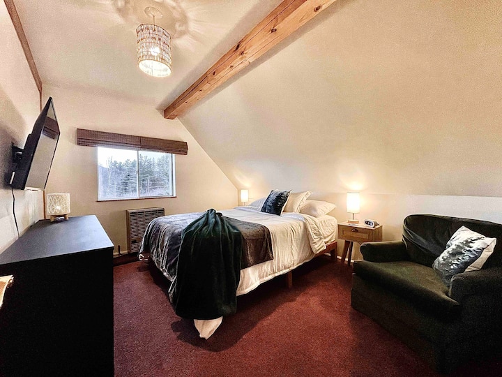 Спална соба со брачен кревет, стол и гардеробер. Оваа соба има 40-инчен телевизор. 