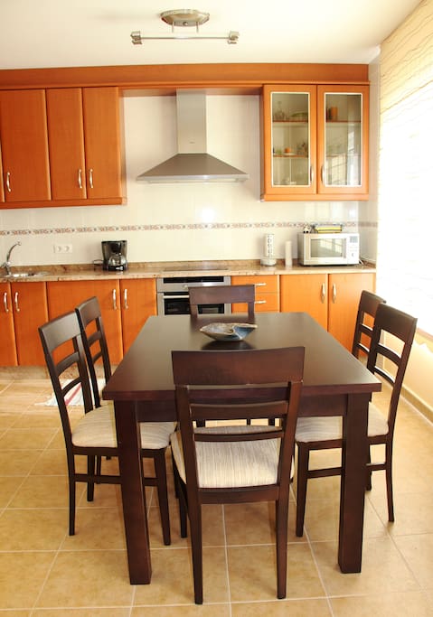 Mesa y seis sillas en el salón-cocina.