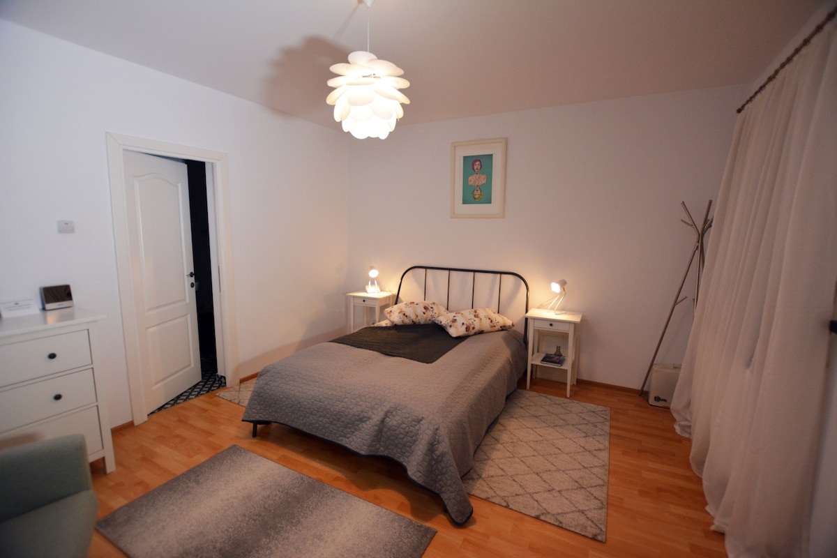 ห้องนอนขนาดกลางมีเตียงขนาดคิงไซส์พื้นที่นั่งเล่นพร้อมเก้าอี้นวม 2 ตัวและอยู่ในห้องน้ำในตัว