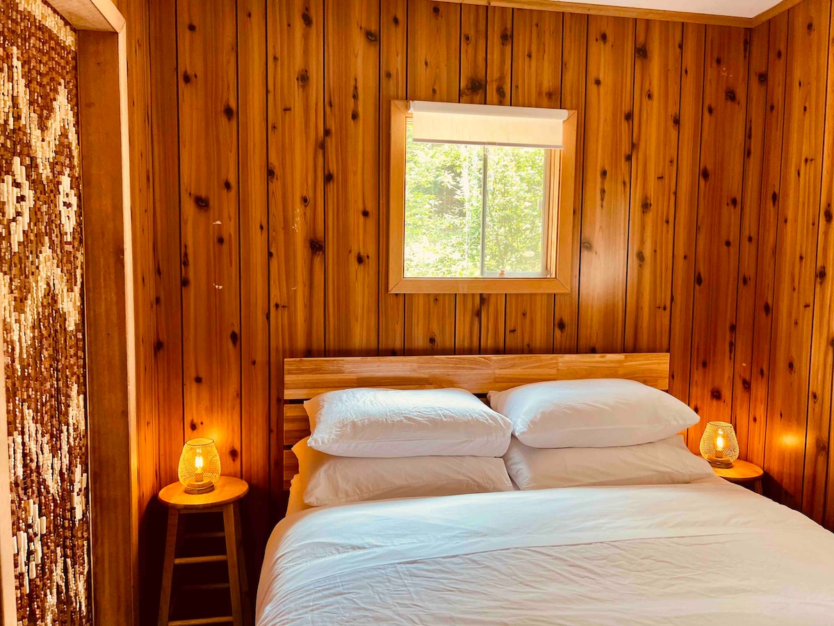 The queen bed made up with cotton linens, down duvet and four pillows. 