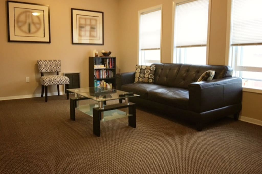 Large, bright living room with comfy leather couch