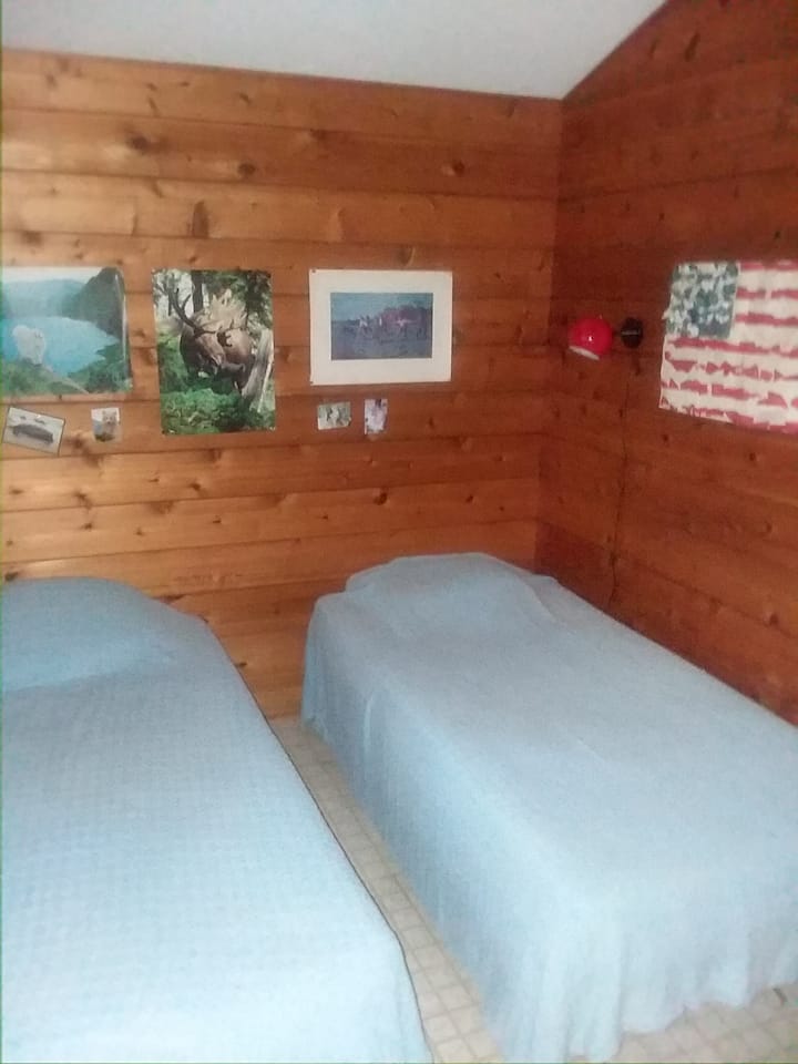 Kleine slaapkamer met enkele bedden uit elkaar; kan ook tegen elkaar geschoven en opgemaakt worden als een koning