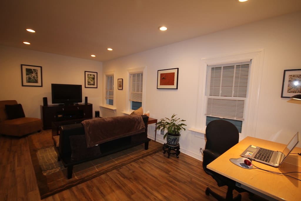 Living room with flat screen TV, surround sound, DVD player, workstation.
