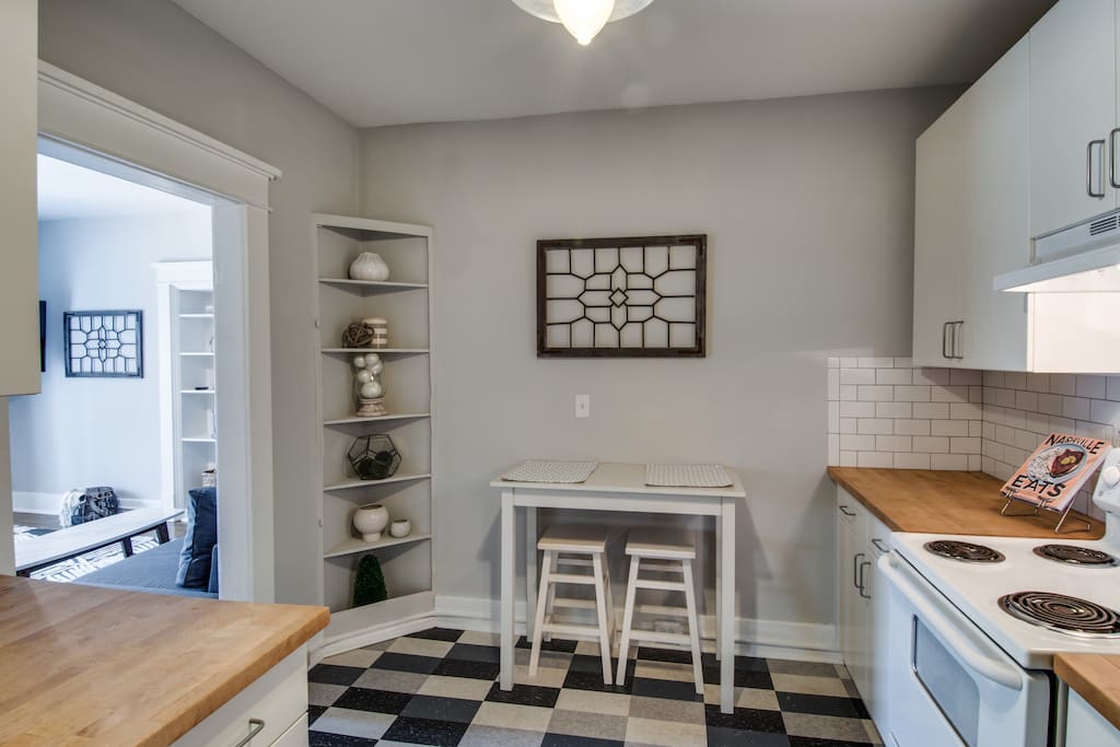 The kitchen features butcher block counters and mosaic tile floors.