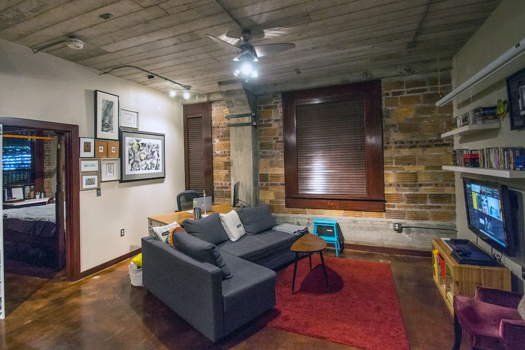 Kick up your feet and hang out. The large window opens up to a balcony and the blue stool comes in handy for getting in and out. Stained cement floors are kid proof and pet proof. Original cement columns, brick and steel featured throughout the unit.