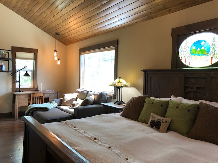 Chambre avec lit King Size Amish en chêne personnalisé, coin salon avec cheminée, bureau/espace de travail ensoleillé, loft et accès à la salle de bain.