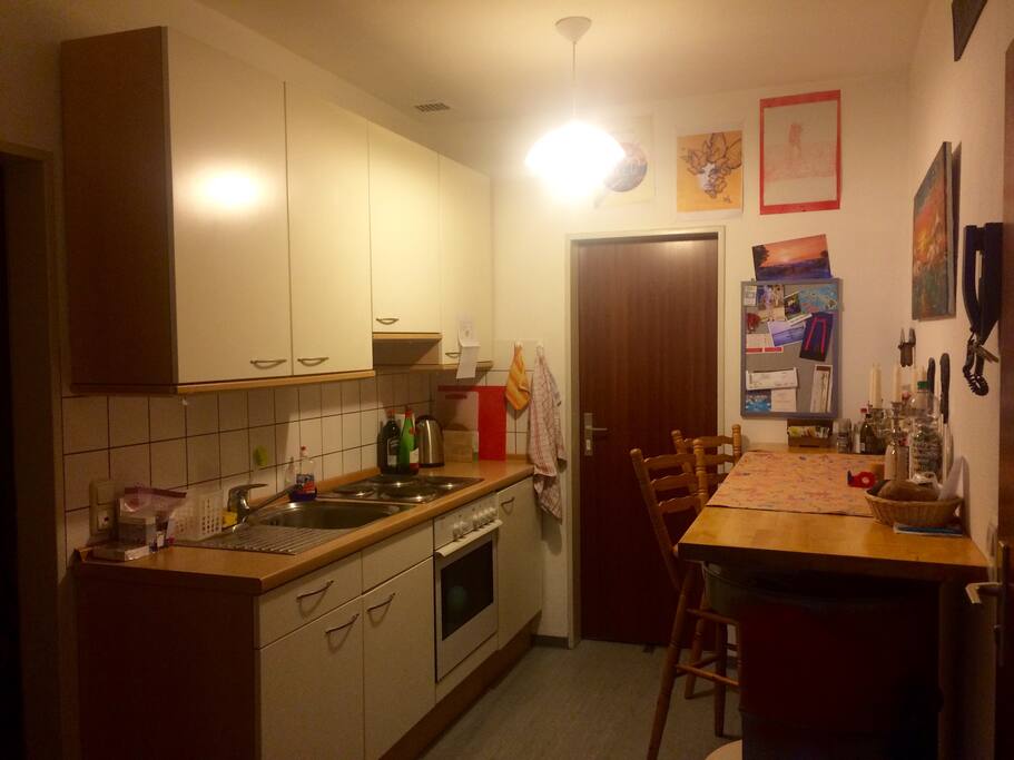 Blick aus dem Wohnraum in die Küche; links: Badezimmertür; hinten: Abstellkammer; rechts: Wohnungstür