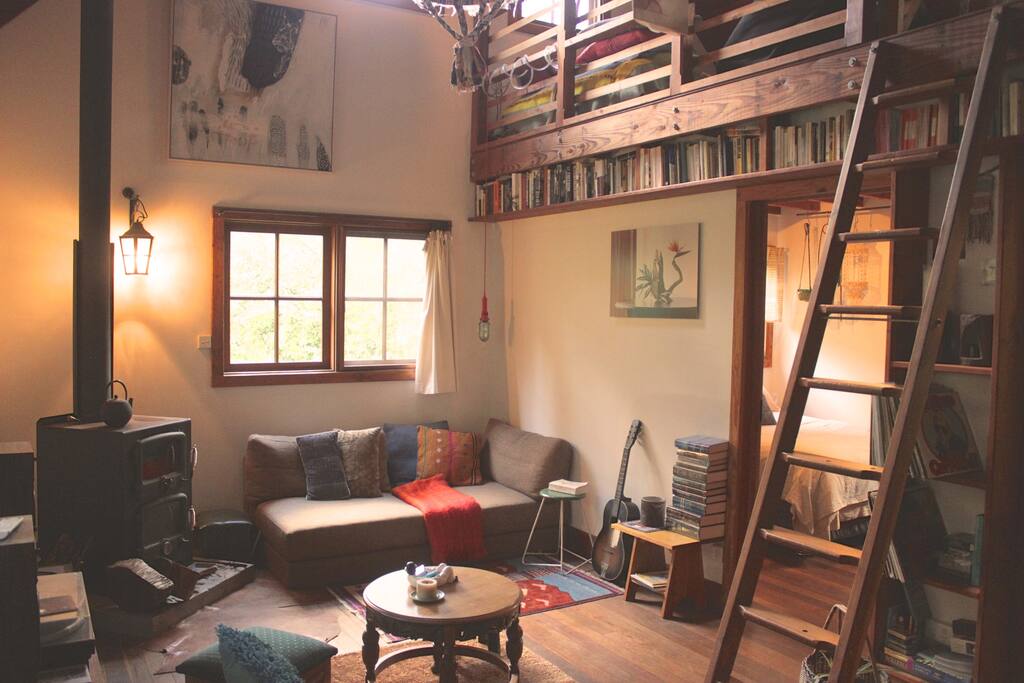 View of the loungeroom with a warming, slow combustion fireplace.