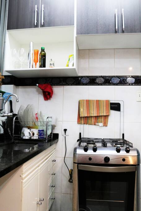 Cozinha equipada com fogão, geladeira e utensílios