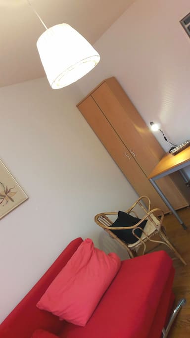 Im Schlafzimmer befindet sich ein Schrank, ein Tisch mit Stuhl und eine kleine Kommode. Es kann zusätzlich ein Büchergestell aufgestellt werden