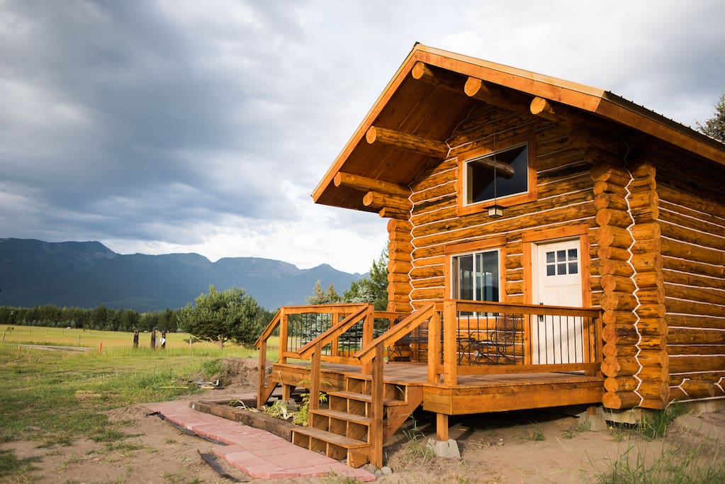 Front of cabin with pastures, 6 horses, and forest between cabin and Mountains. You WILL see deer and maybe even see foxes. You probably won't SEE a bear, but you may see "bear scat". TAKE A JOG AROUND THE 40 acres, going through woods and horse pasture.
