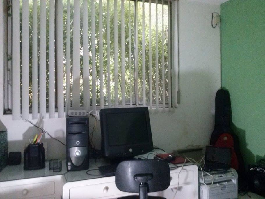 Escritorio con computadora, a la derecha multifuncional.