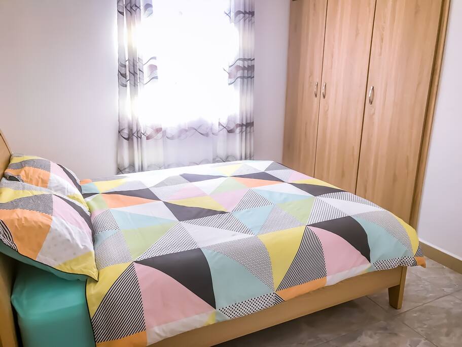 Second bedroom with double bed , bed sides tables and buildin wardrobe.