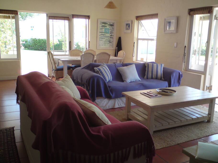 The open plan living area includes comfortable seating, a large dining table and leads onto the patio.