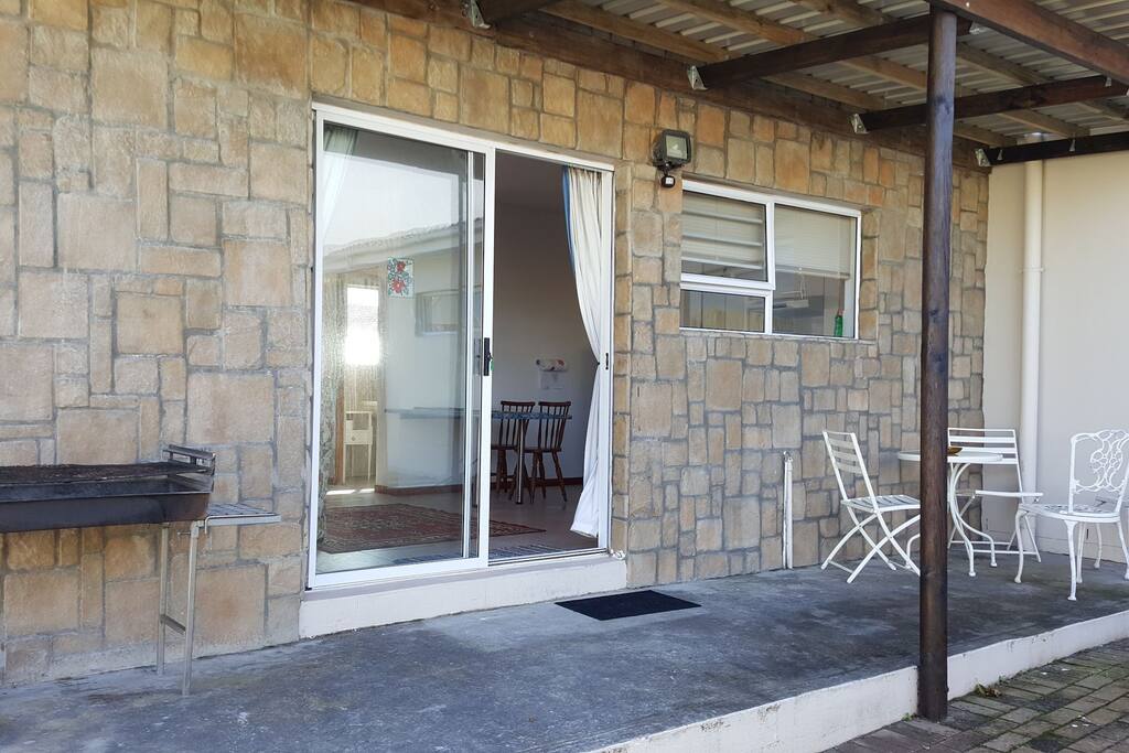 Outside veranda with braai/barbeque facilities with garden furniture.