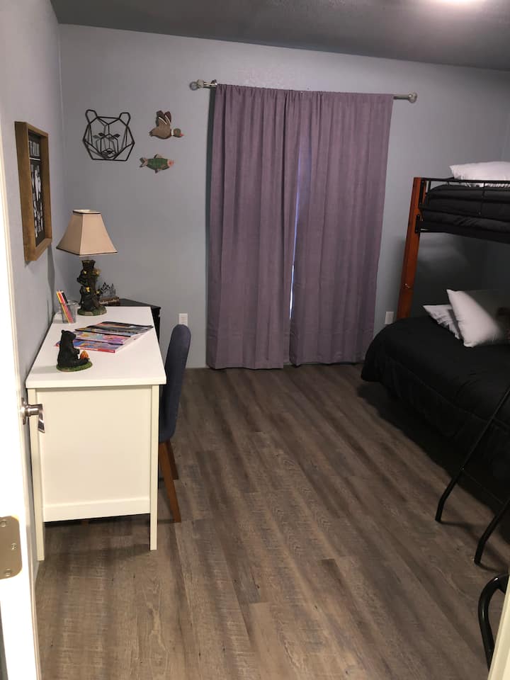 Dormitorio con literas: doble en la parte inferior, individual en la parte superior y escritorio. 